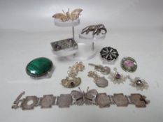 A COLLECTION OF SILVER AND WHITE METAL COSTUME JEWELLERY, comprising mostly brooches, two pairs of