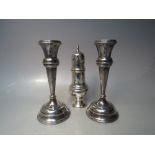 A PAIR OF HALLMARKED SILVER CANDLESTICKS - BIRMINGHAM 1911, filled to bases, H 17.5 cm, together