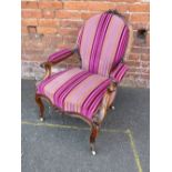 A 19TH CENTURY WALNUT UPHOLSTERED GENTLEMANS OPEN ARMCHAIR, raised on cabriole supports with