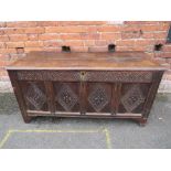 A LATER 18TH CENTURY CARVED OAK FOUR PANEL COFFER, the hinged lid opening to reveal a carved panel
