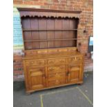 A 19TH CENTURY OAK DRESSER, the enclosed plate rail with a range of five spice drawers above a lower