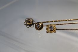 A DIAMOND SET YELLOW METAL STICK PIN, together with a yellow metal gem set example and a