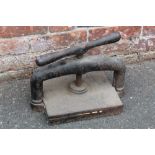 A VINTAGE CAST IRON BOOK PRESS, width of base 25 cm, length of base 30 cm, height when closed 30 cm