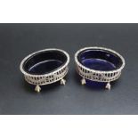 A PAIR OF HALLMARKED SILVER SALTS - LONDON 1903, pierced gallery with blue glass liners and raised