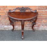 A 19TH CENTURY MAHOGANY DEMI-LUNE CONSOLE TABLE, with carved detail throughout, raised on carved