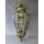 A LARGE BRASS FRAMED HANGING LANTERN, octagonal in form with a coronet top and acanthus bare. The