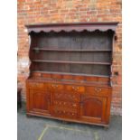 A GEORGIAN OAK DRESSER, the full plate rack with a range of seven spice drawers, the lower section