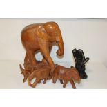 A COLLECTION OF CARVED WOODEN ELEPHANT FIGURES TOGETHER WITH A RESIN FIGURE OF A SEATED FEMALE NUDE