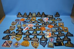 A QUANTITY OF CLOTH POLICE BADGES AND PATCHES to include British, French and American types