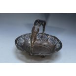 A HALLMARKED SILVER PIERCED SWING HANDLED BASKET BY WALKER & HALL - SHEFFIELD 1919, sitting on