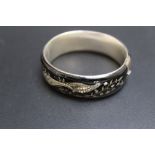 A BLACK ENAMEL STYLE BANGLE, decorated with a bird on a branch, having seed pearl detailing, Dia 6.