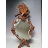 A BLACK FOREST STYLE CARVED WOODEN DECORATIVE WALL MIRROR, with carved eagle surmount, approximate H