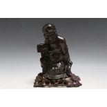 A SMALL CHINESE CARVED HARDWOOD FIGURE OF A SCHOLAR, on fitted base, H 20 cm