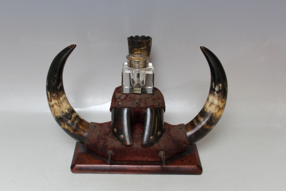 A 19TH CENTURY HORN / HOOF INKSTANDISH, having central glass square inkwell, raised on a mahogany