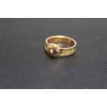 AN ANTIQUE MOURNING RING, the exterior of the band appearing to be inset with gold plated woven hair