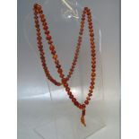 A VINTAGE SINGLE STRAND HAND KNOTTED AMBER BEAD NECKLACE, the beads of varying form, colour and