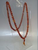 A VINTAGE SINGLE STRAND HAND KNOTTED AMBER BEAD NECKLACE, the beads of varying form, colour and