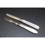 A MATCHED MOTHER OF PEARL HANDLED HALLMARKED SILVER FOLDING FRUIT KNIFE AND FORK SET, the fork dated