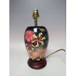 A MOORCROFT 'HONEYSUCKLE' PATTERN TABLE LAMP, with typical tube lined decoration, raised on a