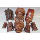A COLLECTION OF SIXTEEN ASSORTED CARVED HARDWOOD EASTERN WALL MASKS, depicting typical figures,