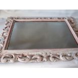 AN 18TH CENTURY CARVED LIMEWOOD FLORENTINE STYLE PICTURE FRAME, later painted and with mirror glass,