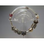 A PANDORA SILVER CHARM BRACELET AND CHARMS, comprising six standard charms and four clip charms,