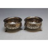 A PAIR OF HALLMARKED SILVER SALT DISHES - BIRMINGHAM 1890, on three pad feet, no liners, approx