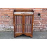 A 20TH CENTURY OAK GLAZED SMALL BOOKCASE CONTAINING SIXTEEN VOLUMES OF THE ENCYCLOPEDIA