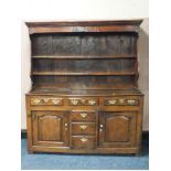A NINETEENTH CENTURY OAK DRESSER, having an overhung enclosed plate rack with inlaid 'D R' initials,