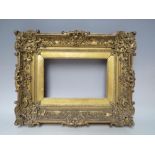 A 19TH CENTURY DECORATIVE SWEPT FRAME WITH INTEGRATED GOLD SLIP, frame & rebate W 8 cm, rebate 13