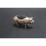 A NOVELTY WHITE METAL PIN CUSHION IN THE FORM OF A PIG, W 5 cm