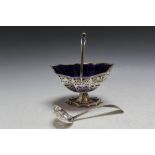 A HALLMARKED PIERCED SILVER SWING HANDLE SUGAR BASKET - BIRMINGHAM 1901, with blue glass liner, W