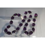 A VINTAGE HAND CRAFTED WHITE METAL AND AMETHYST TYPE COLLARETTE, set with 24 oval faceted stones,