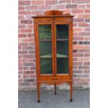 AN EDWARDIAN SATINWOOD PAINTED GLAZED CORNER CABINET, with floral painted detail, raised on