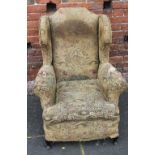 A VINTAGE UPHOLSTERED WINGBACK ARMCHAIR, with hand stitched detail, seat height 42 cm, back height