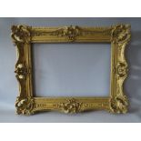 A 19TH CENTURY PIERCED AND SWEPT GOLD FRAME, frame W 9 cm, rebate 50 x 35.5 cm