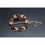 A 9CT GOLD EDWARDIAN SEED PEARL AND GEMSET BROOCH, of circular garland design, attached safety