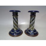 A PAIR OF ROYAL DOULTON POTTERY CANDLESTICKS, spiral embellishment to stem with swags & tail