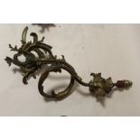 A SET OF FOUR ORNATE SCROLLING BRASS EFFECT WALL LIGHT FITTINGS