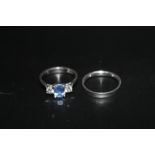 A HALLMARKED PLATINUM THREE SAPPHIRE AND DIAMOND TRILOGY RING, set with an oval sapphire of an