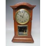AN OAK CASED EDWARDIAN TORSION CLOCK, having a silvered dial, later filigree hands, and bevelled