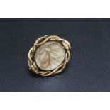 A UNUSUAL ANTIQUE MOURNING BROOCH, having central oval rotating panel set with agate one side and