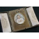 AN OVAL PORTRAIT MINIATURE OF A YOUNG CHILD, Indistinctly signed lower right, framed in a gold metal