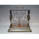 A PLATED TWO BOTTLE TANTALUS STAMPED 'BETJEMANN'S - LONDON'. H 30 cm, W 32 cm