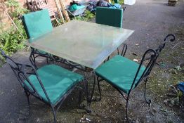 A GLASS TOPPED METAL FRAMED GARDEN TABLE WITH FOUR CHAIRS