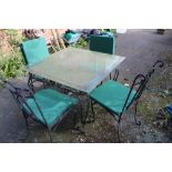 A GLASS TOPPED METAL FRAMED GARDEN TABLE WITH FOUR CHAIRS