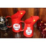 A SET OF 2 REPRODUCTION RED GRADUATING MOBIL GAS CANS