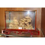 AN ORIENTAL CORK DIARAMA IN GLASS CASE OF TEMPLES IN THE TREES