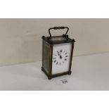 A VINTAGE BRASS AND GLASS CARRIAGE CLOCK