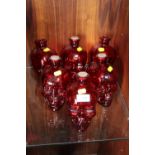 SIX RED GLASS DECANTERS IN THE SHAPE OF SKULLS